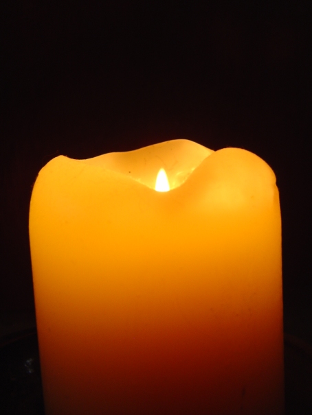 orange candle burning against a black background